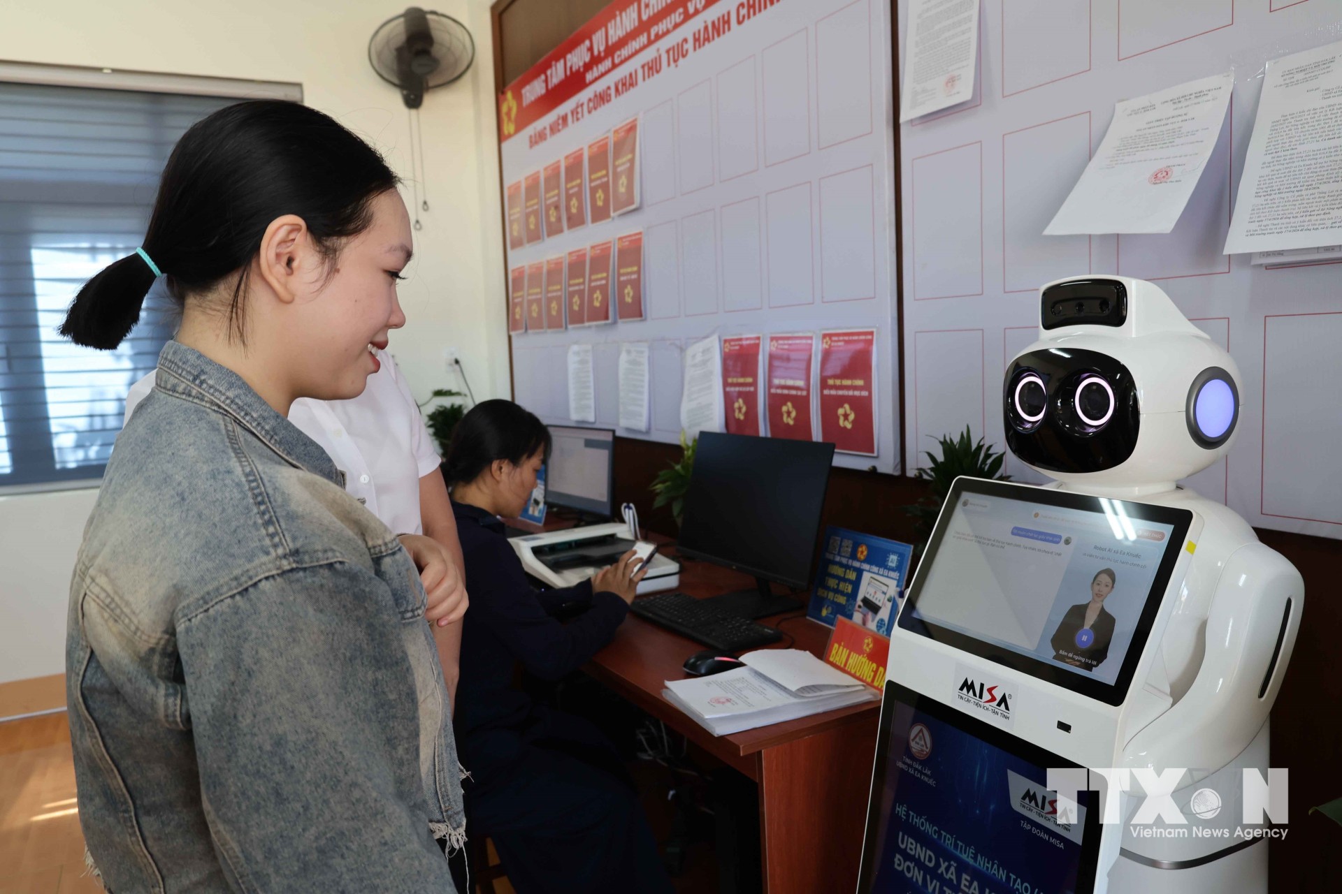 Người dân được robot trợ lý ảo hướng dẫn các bước thủ tục trước khi vào quầy thu tục hành chính tại Trung tâm Phục vụ hành chính công xã Ea K’Nuếc, tỉnh Đắk Lắk. (Ảnh: Hải Âu/TTXVN)